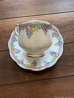 Teacup on saucer showing floral pattern and gold trim