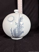 Front view showing painted plum blossoms under full moon, shape and glaze