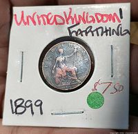Obverse view of coin in holder showing Britannia and handwritten details