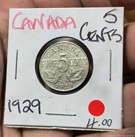 Reverse view of coin in holder, date 1929 visible