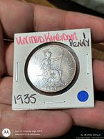 Reverse of 1935 penny showing seated Britannia and date, coin in flip