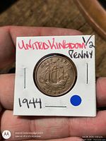 Reverse side of 1944 Half Penny in flip showing sailing ship design and handwritten label