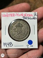 Obverse of 1948 2 shillings coin in flip, King George VI portrait visible