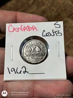 Coin reverse in flip showing beaver and date 1962