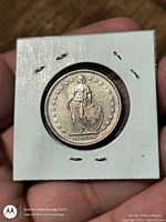 Obverse of 1968 Swiss 2 F coin in flip, standing Helvetia visible