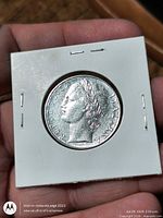 Obverse of 1976 Italy 100 Lira coin in cardboard flip
