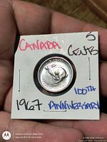 Reverse of 1967 Canadian 5-cent coin in flip, rabbit design visible