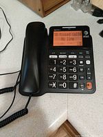 Front view of AT&T corded phone showing keypad, display and coiled handset cord