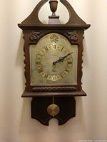 Full view of Bulova wooden wall clock with pendulum