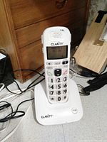 Front view of handset on charging base showing buttons and display