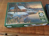 Cobble Hill 1000+ piece puzzle box front showing winter cabin scene