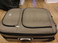 Full view of Destiny King brown houndstooth suitcase lying flat