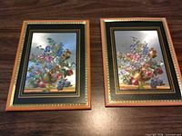 Pair of framed prints on tabletop showing full fronts