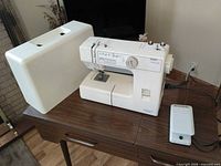 Pfaff Hobby 382 sewing machine with hard cover, foot pedal and power cord on table
