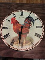 Front view showing rooster graphic, numerals, border and hands