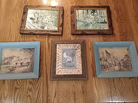 Overview of five framed prints on floor