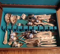 Open case showing assorted flatware pieces scattered inside