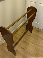 Overall view of brown plywood quilt rack