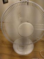 Front view of white table fan showing full grille and base