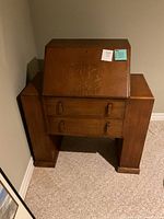 Front view of solid wood drop-front secretary desk showing two drawers and closed writing surface