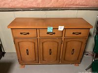 front view of honey sideboard showing drawers, doors, hardware