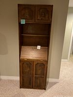 full front view of tall secretary bookcase showing upper cabinets, open shelf, drop-front desk, and lower cabinets