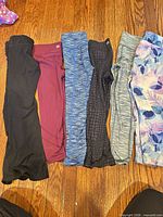 Six pairs toddler leggings laid out side by side on floor