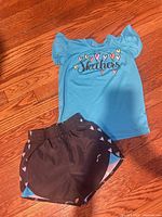 T-shirt and shorts laid flat on floor showing full outfit