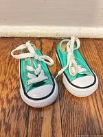 Top view of both mint green infant Converse sneakers showing uppers, laces and toe caps