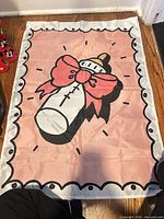 Full view of pink gender reveal flag laid flat