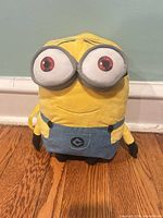 Front view of yellow Minion plush backpack standing upright