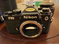 Front view Nikon FE2 body with large zoom lens beside