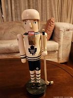 Front view of wooden Toronto Maple Leafs hockey player statue with stick