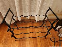 Three-tier metal rack, front view showing tiers and feet