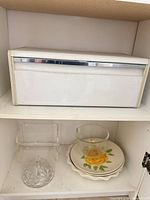 Bread box closed and serving pieces on shelf