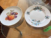 Stack of Bavaria fruit-motif plates beside Windsor floral plate