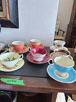 All six cup and saucer sets displayed