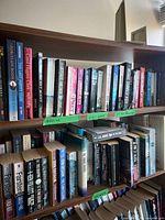 Top two shelves of bookcase showing mix of hard and soft cover books
