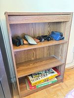 Front view of brown three-tier bookshelf showing shelves and wood-grain finish