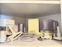 Attachments, bowls, paddle, adaptors visible inside cupboard