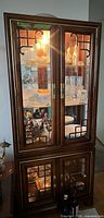 Full view of illuminated wood and glass china cabinet