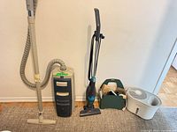Group shot showing Electrolux canister vacuum, stick vacuum, green caddy with accessories, and white tabletop humidifier