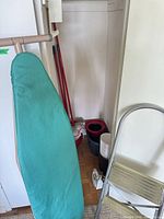 Ironing board, step stool, mop bucket, waste bin, mop handles in closet
