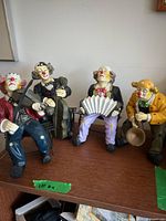 Group shot of all four clown musician figurines on shelf