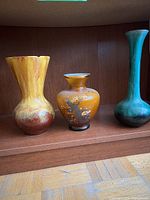 Front view of three vases on shelf
