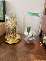 Clock and vase on table