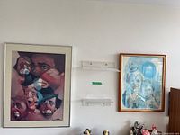 Both framed prints on wall showing relative sizes