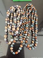 Two coiled multicolor pearl strands on table