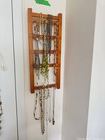 Full view of wall organizer with hanging necklaces and bracelet