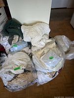 Four clear plastic bags filled with assorted linens and towels